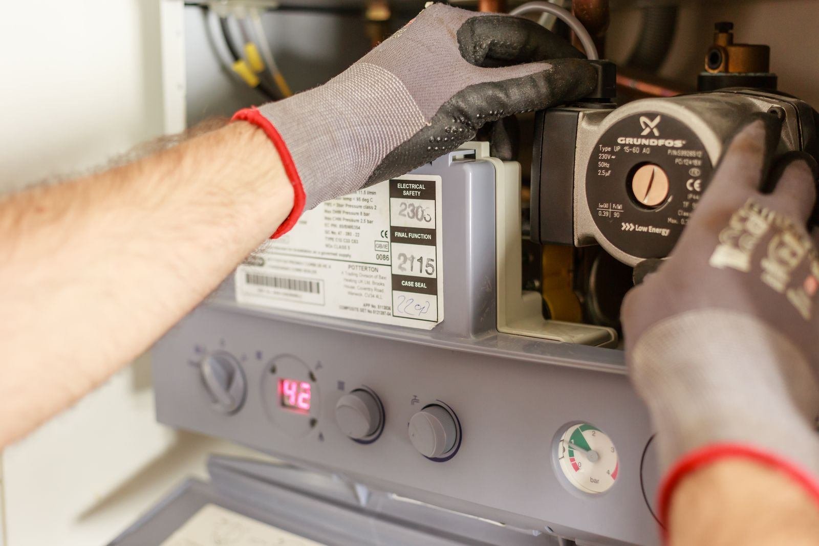 Technician servicing a residential water heater control panel in Chicago